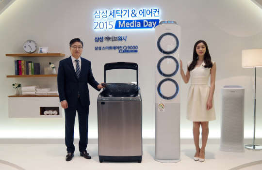 지난 3일  서초동 삼성전자 서초사옥 다목적홀 5층에서 윤부근 삼성전자 CE부문 사장과 김연아가 '액티브워시' 세탁기와 2015년형 '스마트에어컨 Q9000'과 함께 기념촬영을 하고 있는 모습. <삼성전자 제공>